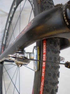 Close-up of shortened brake pads and holders with new holes drilled for pad-retention cotters.