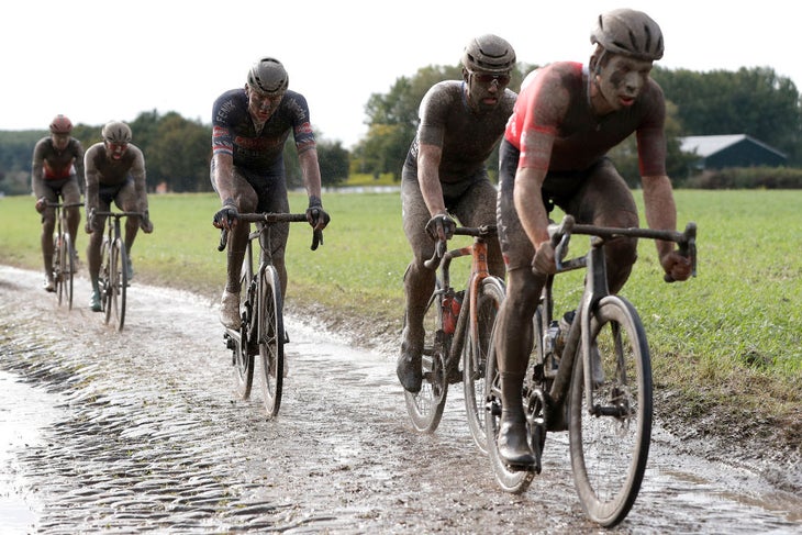 ROUBAIX, FRANCE - OCTOBER 03: (L-R) Mathieu Van Der Poel of Netherlands and Team Alpecin-Fenix and Sonny Colbrelli of Italy and Team Bahrain Victorious covered in mud compete through cobblestones sector during the 118th Paris-Roubaix 2021 - Men's Eilte a 257,7km race from Compiègne to Roubaix / #ParisRoubaix / on October 03, 2021 in Roubaix, France. (Photo by Bas Czerwinski/Getty Images)