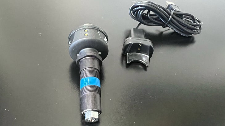 The Favero Assioma Shi power meter spindle and charging cable.