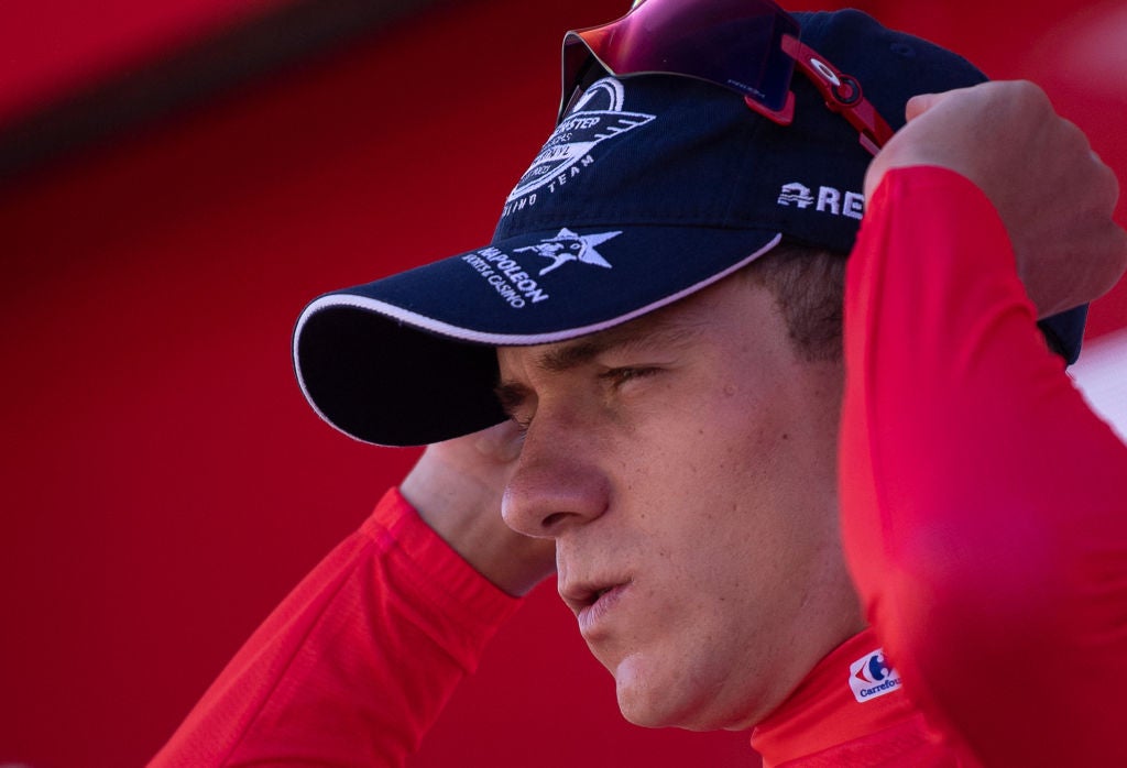 Team Quick Step's Belgian rider Remco Evenepoel celebrates on the podium wearing the overall leader's red jersey after the 17th stage of the 2022 La Vuelta cycling tour of Spain, a 162.3km race from Aracena to the Monasterio de Tentudia monastery in Calera de Leon, on September 7, 2022. (Photo by JORGE GUERRERO / AFP) (Photo by JORGE GUERRERO/AFP via Getty Images)