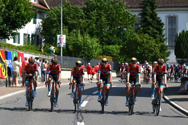 The Bahrain-Victorious riders lead the procession honoring Gino Mader