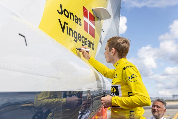 Denmark's Jonas Vingegaard rider of the Jumbo-Visma team and winner of the 2023 edition of the Tour de France, writes his autograph on the the airplane as he arrives at Copenhagen airport, Denmark, on July 26, 2023. Denmark's Jonas Vingegaard of the Jumbo-Visma team won his second successive Tour de France on July 23, 2023 after Jordi Meeus claimed the final stage honours on the Champs-Elysees in Paris. He crossed the finish line after the 21-day race 7min 29sec ahead of Slovenia's Tadej Pogacar, the champion in 2020 and 2021. (Photo by Ólafur Steinar Rye Gestsson / Ritzau Scanpix / AFP) / Denmark OUT
