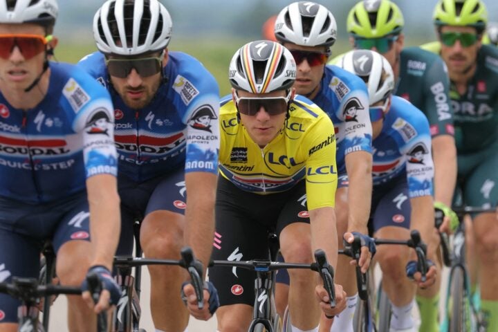 Team Soudal's Belgian rider Remco Evenepoel wearing the overall leader's yellow jersey (C) rides in the pack during the sixth stage of the 76th edition of the Criterium du Dauphine cycling race, 174,1km between Hauterives and Le Collet d'Allevard, French Alps, on June 7, 2024. (Photo by Thomas SAMSON / AFP)