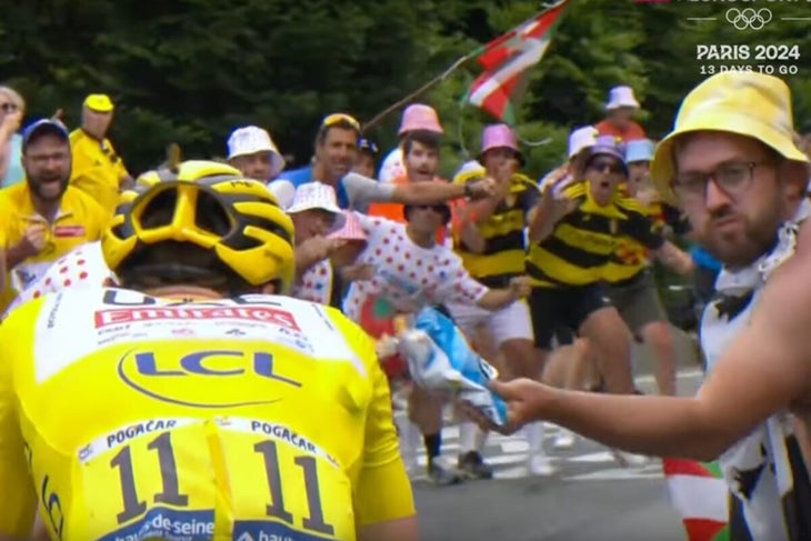 A spectator throws potato chips at race leader Tadej Pogaćar (UAE Team Emirates) on stage 14 of the 2024 Tour de France. (Photo: Eurosport screenshot)