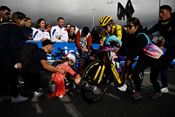 Canyon//SRAM Racing team's Polish rider Katarzyna Niewiadoma (3rd R) celebrates after crossing the finish line and winning the third edition of the Women's Tour de France cycling race, as she cycles past stage winner Team SD Worx - Protime's Dutch rider Demi Vollering (C) sitting on the side of the road at the end of the 8th and last stage of the Tour de France, a 149.9 km between Le Grand Bornand and the Alpe d'Huez, in south-eastern France, on August 18, 2024. (Photo by JULIEN DE ROSA / AFP)