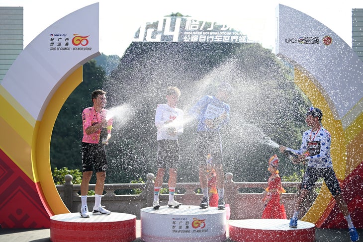 Emerging Talent Lennert Van Eetvelt seals Tour of Guangxi win 3 NONGLA, CHINA - OCTOBER 19: (L-R) Stefan Bissegger of Switzerland and Team EF Education - EasyPost - most combative rider prize winner, stage winner Lennert Van Eetvelt of Belgium and Team Lotto Dstny - White Best Young Rider Jersey, Ethan Vernon of The United Kingdom and Team Israel - Premier Tech - Blue Points Jersey and Pepijn Reinderink of The Netherlands and Team Soudal Quick-Step - Polka Dot Mountain Jersey celebrate with champagne on the podium ceremony after the 5th Gree-Tour Of Guangxi 2024, Stage 5 a 165.8km stage from Yizhou to Nongla 641m / #UCIWT / on October 19, 2024 in Nongla, China. (Photo by Dario Belingheri/Getty Images)
