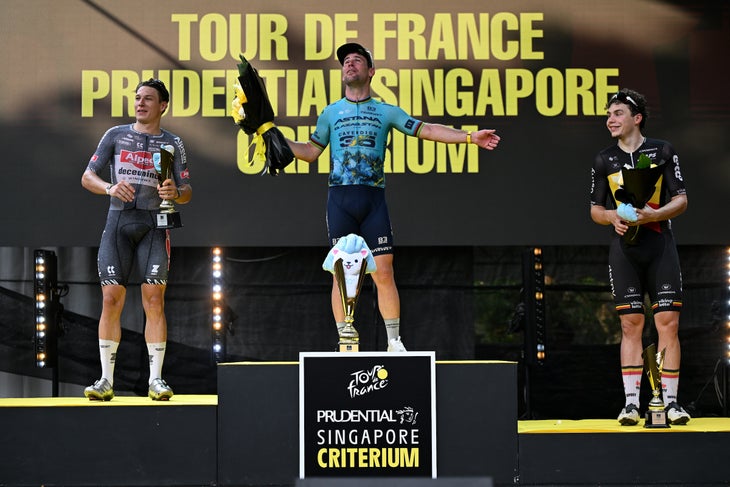 Cavendish Retires with ‘Win’ at Singapore Criterium 3 SINGAPORE, SINGAPORE - NOVEMBER 10: (L-R) Jasper Philipsen of Belgium and Team Alpecin-Deceuninck on second place, race winner Mark Cavendish of The United Kingdom and Astana Qazaqstan Team and Arnaud De Lie of Belgium and Team Lotto Dstny on third place pose on the podium ceremony after the 3rd Tour de France Prudential Singapore 2024 - Criterium a 57.5km one day race from Singapore to Singapore on November 10, 2024 in Singapore. (Photo by Tim de Waele/Getty Images)