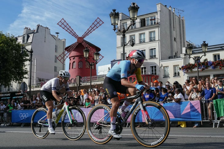 Belgium's Lotte Kopecky (R) and US' Kristen Faulkner (L) cycle past the Moulin Rouge cabaret during the women's cycling road race during the Paris 2024 Olympic Games in Paris, on August 4, 2024. (Photo by Dimitar DILKOFF / AFP)