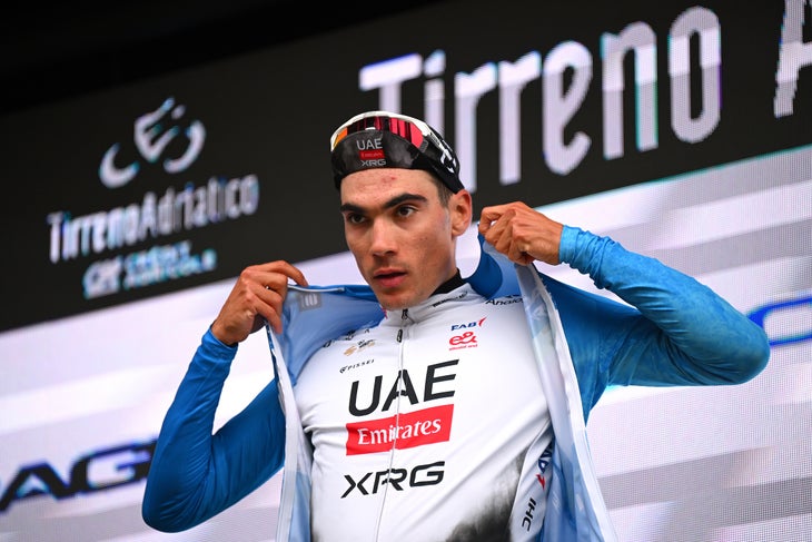 FRONTIGNANO, ITALY - MARCH 15: Juan Ayuso Pesquera of Spain and UAE Team Emirates XRG celebrates at podium as Blue Leader Jersey winner during the 60th Tirreno-Adriatico 2025, Stage 6 a 163km stage from Cartoceto to Frontignano 1324m / #UCIWT / on March 15, 2025 in Frontignano, Italy. (Photo by Tim de Waele/Getty Images)