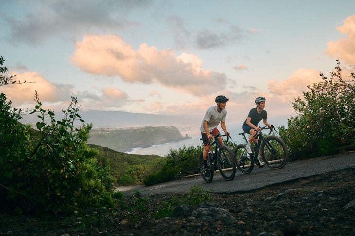 Bikers ride up a hill
