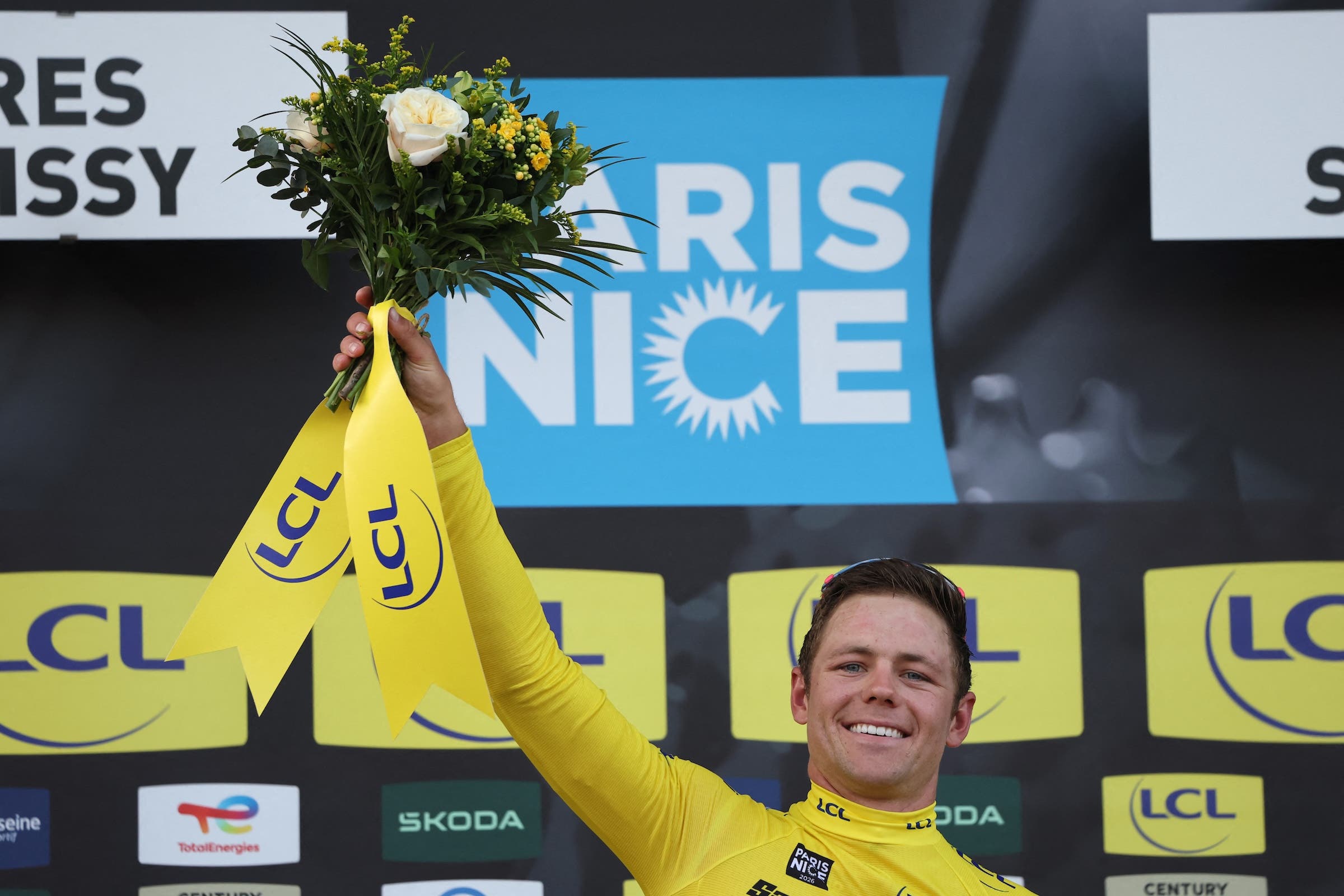 EF Education - EasyPost's US rider Luke Lamperti celebrates his overall leader yellow jersey on the podium after the 1st stage of the Paris-Nice cycling race, 170.9 km between Achères and Carrières-sous-Poissy, on March 8, 2026. (Photo: Anne-Christine Poujoulat / AFP)