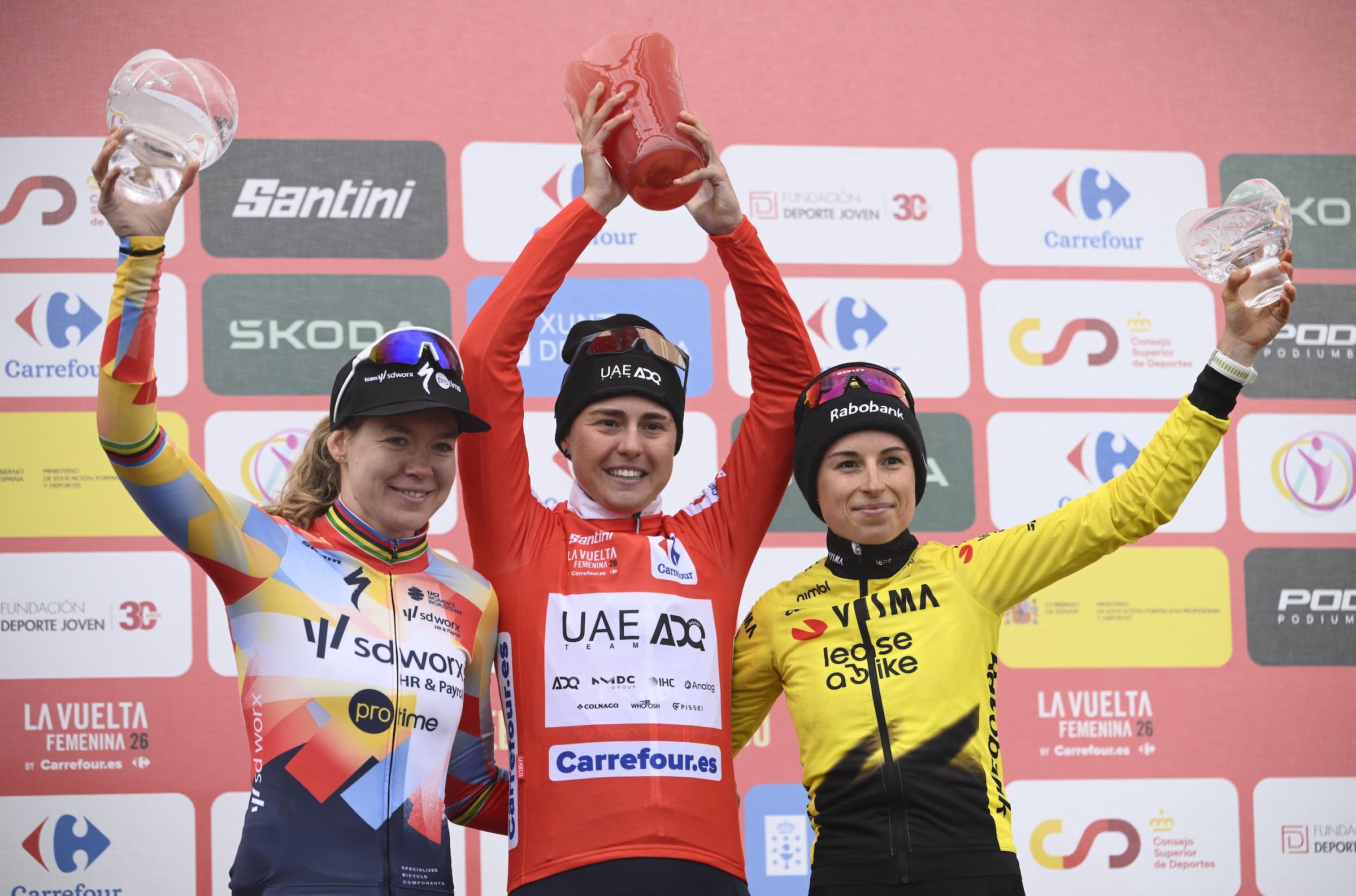 Paula Blasi celebrates victory in La Vuelta Femenina, alongside Anna van der Breggen and Marion Bunel (Photo: Miguel RIOPA / AFP)