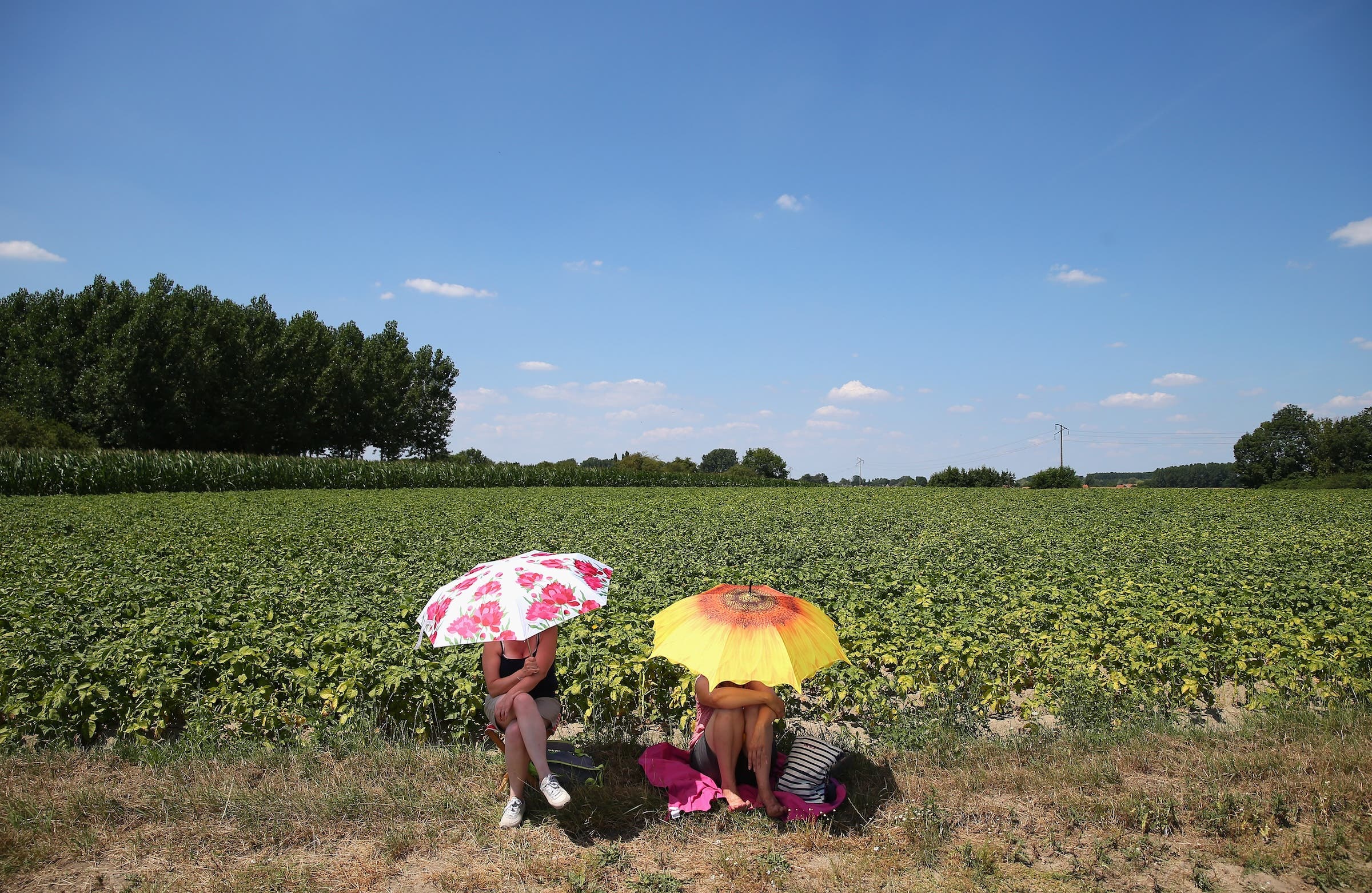 Two spectators try to shelter from the sun at the Tour (Photo: Getty Images)