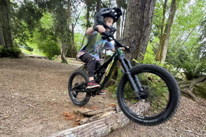A child rides over a small jump.