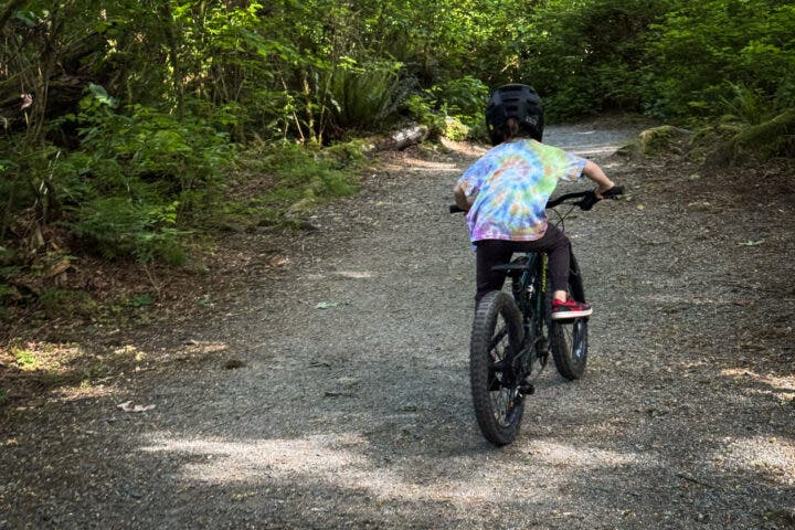 A child rides on a bike path.